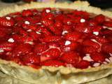 Tarte aux fraises sur une crème légère avec un voile de gelée de fraises et coquelicots